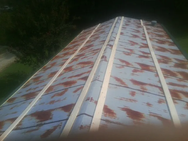 Rusted metal roof panels with new wood purlins before replacement — Storm Damage Roof Repair in China by Roofing Brothers